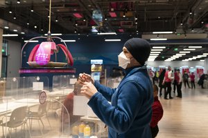 Canadian technician Matthew Potvin reaches for his lunch delivered to him robotically in the dining area of the main media center at the 2022 Winter Olympics, Monday, Jan. 24, 2022, in Beijing