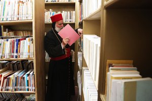 In this Thursday, April 2, 2015 photo, Archbishop for northern Iraq, Saliba Shimon, works on books at the library at the Mar Matti monastery outside the town of Bashiqa, north of Mosul, northern Iraq, where he teaches the old Syriac language