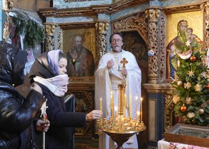 People light candles in a church to mark Orthodox Christmas in the village of Pirogovo outside the capital Kyiv, Ukraine, Friday, Jan. 7, 2022