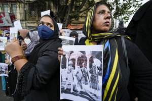 Indian Muslim women hold placards during a protest against banning Muslim girls wearing hijab from attending classes at some schools in the southern Indian state of Karnataka, in Kolkata, India, Thursday, Feb. 10, 2022