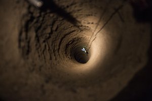 Afghan National Army soldiers with the 3rd Company, 6th Battalion and U.S. Soldiers with the 1st Battalion, 36th Infantry Regiment, send a rope with chem lights to get view of how deep a well is, that young boy has fallen into, in Maiwand district, Kandahar province, Afghanistan