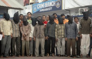 FILE- Nine men, wearing black hoods to conceal their identity, arrested by the Ahmedabad crime branch for allegedly conducting a series of bombings, are shown to the media in Ahmadabad, India, Saturday, Aug. 16, 2008.