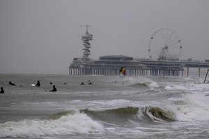 Surfers wait for waves whipped up by storm Eunice at Scheveningen, the Netherlands, on Friday Feb. 18, 2022.