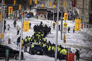 Police officers gather near the site of a trucker blockade in Ottawa, Friday, Feb. 18, 2022