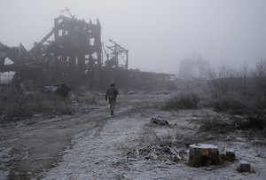 In this Nov. 19, 2019 file photo, a Ukrainian soldier passes by a destroyed Butovka coal mine as he approaches his front line position in the town of Avdiivka in the Donetsk region, Ukraine. It is Ukraine, not Russia, where the economy is eroding the fastest under the threat of war. Even before Russia launched its latest invasion, costing 70 years of hard-won European peace, Ukraine was the biggest loser in the agonizing, slow-motion aggression.