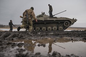 Ukrainian servicemen walk on an armored fighting vehicle during an exercise in a Joint Forces Operation controlled area in the Donetsk region, eastern Ukraine, Thursday, Feb. 10, 2022