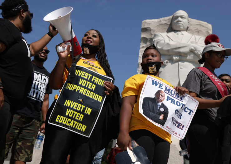 Photo of people holding signs at a voting rights rally