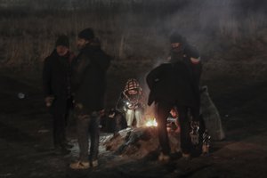 Students gather around a camp fire to warm themself at the Medyka border crossing after fleeing from the Ukraine, in Poland, Monday, Feb. 28, 2022. The head of the United Nations refugee agency says more than a half a million people had fled Ukraine since Russia's invasion on Thursday