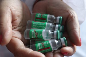 A medic shows Covishield the second dose of the COVID-19 vaccine to a beneficiary at a health centre in Jammu, India, 16 May 2021.