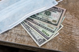 Medical mask with dollars on wooden table. Masks sold out during Coronavirus outbreak