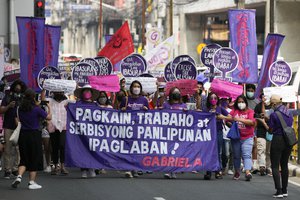 Protesters march during a rally near the Malacanang presidential palace in Manila, Philippines to mark International Women's Day on Tuesday, March 8, 2022