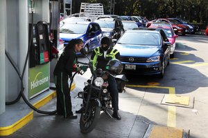 Vehicles stand in line to fill up their fuel tanks at a gas station in Mexico, City, Wednesday, Jan. 9, 2019.