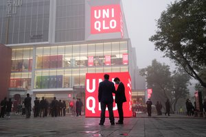 Attendees gather near the new global flagship store for apparel giant Uniqlo in Beijing, China, Saturday, Nov. 6, 2021.