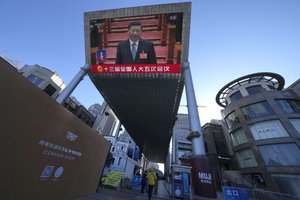 Chinese President Xi Jinping is seen on a live broadcast of the opening ceremony for the National People's Congress at a mall on Saturday, March 5, 2022, in Beijing.