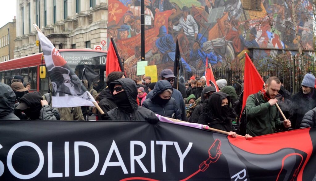 A march behind a banner saying "solidarity" related to the Rupression campaign about political trials and repression of anarchists and antifascists by the Russian gov.