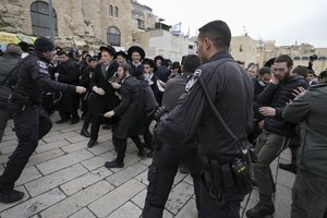 Police scuffle with Ultra-Orthodox Jews during a protest against the group Women of the Wall as they hold their new month prayer at the Western Wall, the holiest site where Jews can pray, in Jerusalem's Old City, Friday, March 4, 2022.