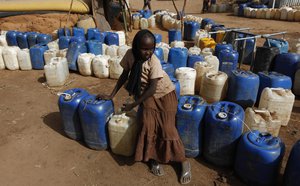 File - A Sudanese girl waits to collect water supplies in a water station at the refugee camp of Zamzam at the outskirts of the Darfur town of el Fasher.