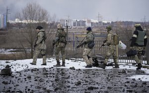 Ukrainian servicemen walk in Irpin, on the outskirts of Kyiv, Ukraine, Tuesday, March 8, 2022