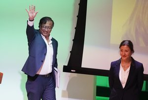 Presidential candidate Gustavo Petro with the Historical Pact coalition waves as presidential candidate Ingrid Betancour with the Green Oxygen Party smiles, before the start of a presidential debate at the Externado University in Bogota, Colombia, Tuesday, March 29, 2022, ahead of the May 29th elections.