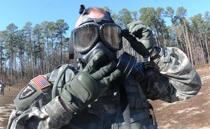 Sgt. Bryan Teneyck, representing the Installation Mangement Command, adjusts his mask during one of the Chemical, Biological, Radiological, Nuclear and Explosives tasks on the first day of the 2013 Best Warrior Competition, 20 November, 2013.