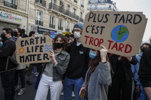 Youths hold placards during a rally against the climate change in Paris, Sunday, March 28, 2021.