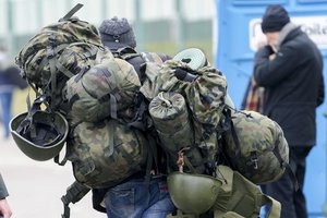 FILE - A man carries combat gear as he leaves Poland to fight in Ukraine, at the border crossing in Medyka, Poland, Wednesday, March 2, 2022.