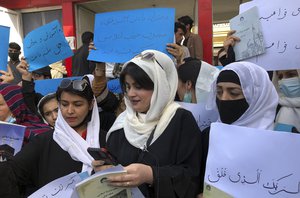 Afghan women chant and hold signs to protest during a demonstration in Kabul, Afghanistan, Saturday, March 26, 2022. Afghanistan's Taliban rulers refused to allow dozens of women to board several flights, including some overseas, because they were traveling without a male guardian, two Afghan airline officials said Saturday.