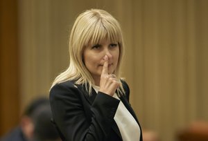 FILE - In this Monday, Feb. 9, 2015 file photo, Elena Udrea touches her nose after delivering a speech in parliament pleading with fellow lawmakers not to approve her arrest in Bucharest, Romania.