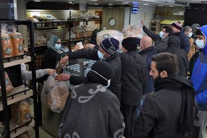 People queue for bread inside a bakery in the southern Beirut suburb of Dahiyeh, Lebanon, Tuesday, March 15, 2022