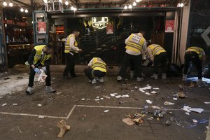 Members of Israeli Zaka Rescue and Recovery team cleans blood from the site of a shooting attack In Tel Aviv, Israel, Thursday, April 7, 2022.