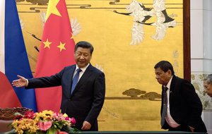 In this Thursday, Oct. 20, 2016 file photo, Philippine President Rodrigo Duterte, right, is shown the way by Chinese President Xi Jinping before a signing ceremony in Beijing, China.