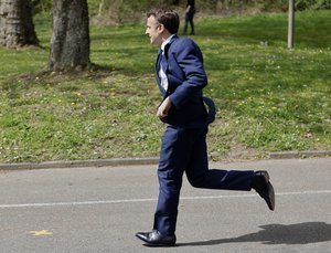 Current French President and centrist presidential candidate for reelection Emmanuel Macron runs to greet supporters as he arrives to visit Alister, a training center for functional rehabilitation, in Mulhouse eastern France, Tuesday, April 12, 2022.