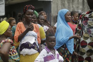 File - Women and children from Makoko slum wait for a planned food distribution by the Nigerian Red Cross for those under coronavirus related movement restrictions, in Lagos, Nigeria, Saturday, April 25, 2020.