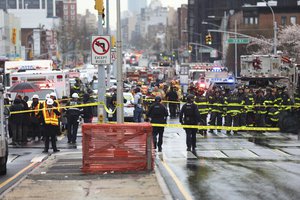 Law enforcement gather near the entrance to a subway stop in the Brooklyn borough of New York, Tuesday, April 12, 2022