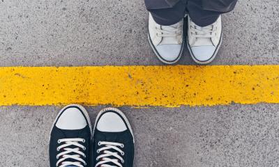 two people standing on yellow line