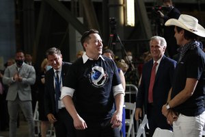 Tesla and SpaceX Chief Executive Officer Elon Musk stands as his brother Kimbal Musk, right, and House Minority Leader Kevin McCarthy of Calif.