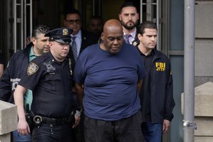 New York City Police, left, and law enforcement officials lead subway shooting suspect Frank R. James, 62, center, away from a police station, in New York, Wednesday, April 13, 2022.