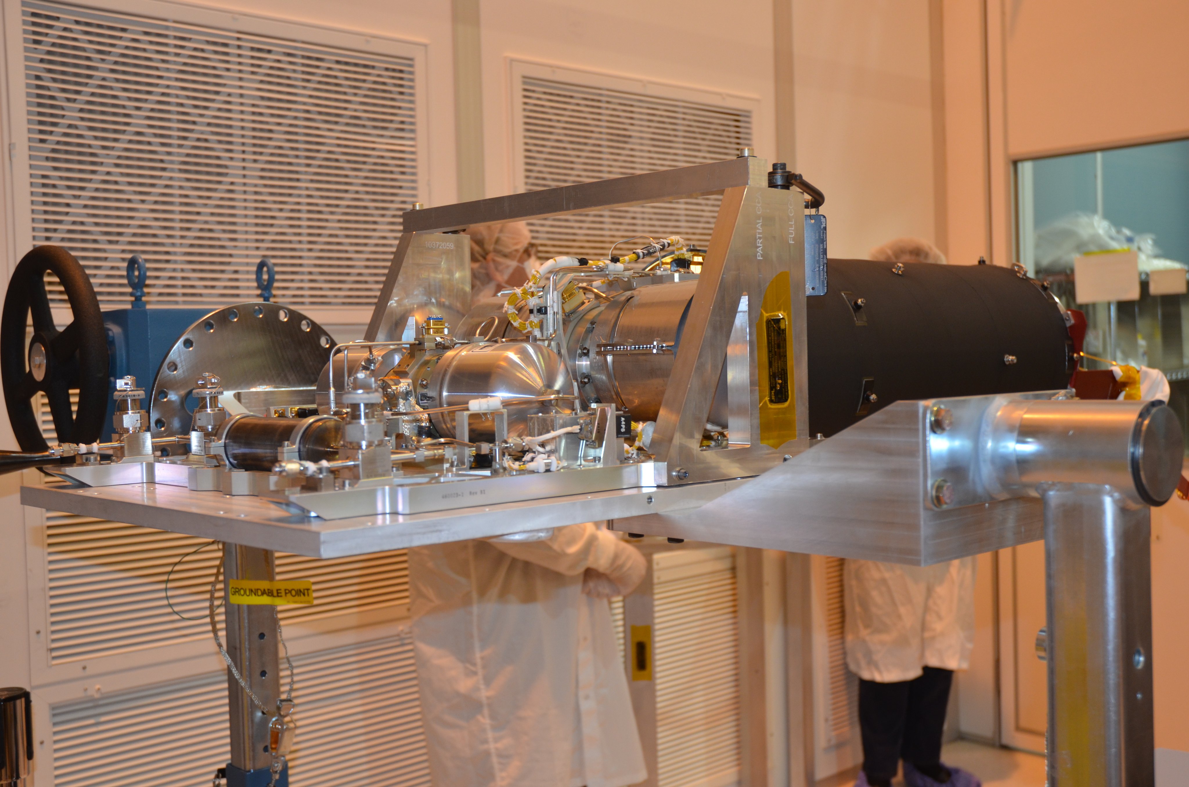 This image shows the cryocooler for the Webb telescope's Mid-Infrared Instrument, or MIRI. The cryocooler, a silver metallic device, is a special refrigerator to cools MIRI down to less than 7 Kelvin. This photo was taken after the cryocooler had completed testing, and was taken out of the test chamber in preparation for being placed into its shipping container.