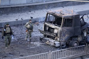 Ukrainian troops inspect the site following a Russian airstrike in Kyiv, Ukraine, Saturday, Feb. 26, 2022.