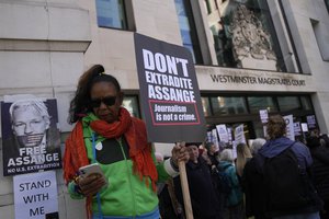 Wikileaks founder Julian Assange supporters hold placards as they gather outside Westminster Magistrates court In London, Wednesday, April 20, 2022.