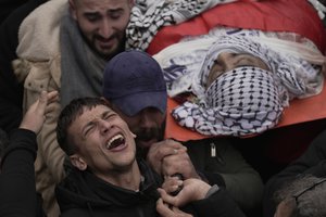 Palestinian mourners carry the body of Ahmad Saif, 23, who died as a result of injuries sustained on March 1, during clashes with Israeli soldiers following a demonstration, during his funeral in the West Bank village of Burqa, March 9, 2022