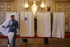 A man leaves a voting booth at a polling station before voting Sunday, April 24, 2022 in Strasbourg, eastern France. France began voting in a presidential runoff election with repercussions for Europe's future, with centrist incumbent Emmanuel Macron the front-runner but fighting a tough challenge from far-right rival Marine Le Pen