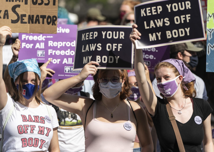 Photo of three young people holding signs that say Bans Off My Body