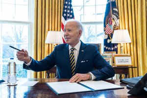 File - President Joe Biden signs an Executive Order banning the import of Russian oil, Tuesday, March 8, 2022, in the Oval Office of the White House.