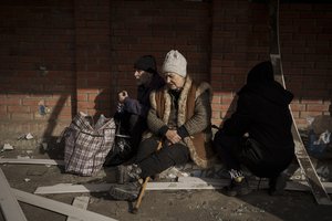 People fleeing the village of Ruska Lozova wait at a screening point in Kharkiv, Ukraine, Friday, April 29, 2022.