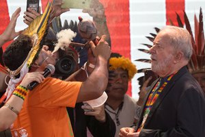 Brazil's former President Luiz Inacio Lula da Silva takes part in a spiritual ritual led by a chief, during the 18th annual Free Land Indigenous Camp, in Brasilia, Brazil, Tuesday, April 12, 2022.