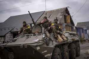 Ukrainian soldiers drive on an armored military vehicle in the outskirts of Kyiv, Ukraine, Saturday, March 5, 2022.