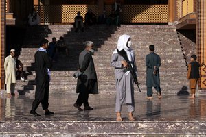 A Taliban fighter stands guard in a mosque at the first day of Eid al-Fitr in Kabul, Afghanistan, Sunday, May 1, 2022. Eid al-Fitr prayer marks the end of the holy fasting month of Ramadan in Afghanistan.