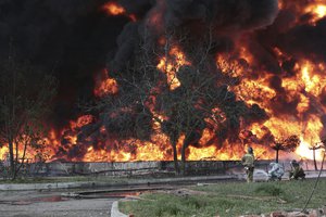 Donetsk People Republic Emergency Situations Ministry firefighters work at the site of fire at the oil depot after missiles struck the facility in an area controlled by Russian-backed separatist forces in Makiivka, 15 km (94 miles) east of Donetsk, eastern Ukraine, Wednesday, May 4, 2022.