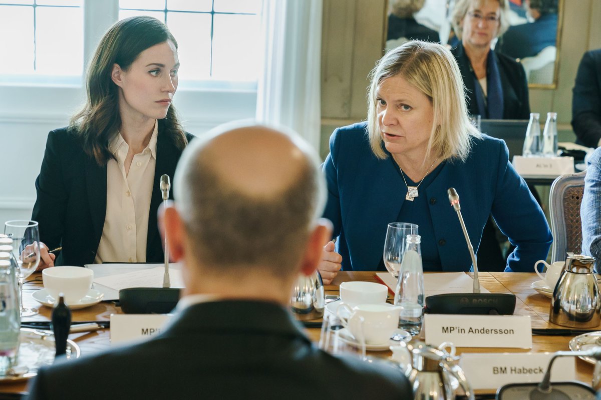 Die finnische Ministerpräsidentin Sanna Marin und ihre schwedische Amtskollegin Magdalena Andersson sitzen an einem Tisch dem Bundeskanzler gegenüber und sind in ein gespräch vertieft. Vom Kanzler ist nur der Rücken zu erkennen.
